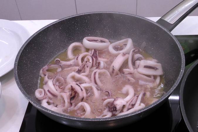 Verter el vino blanco y cocinar los calamares