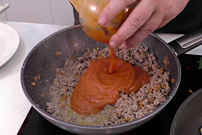 Desmenuzar la carne y añadir el tomate frito