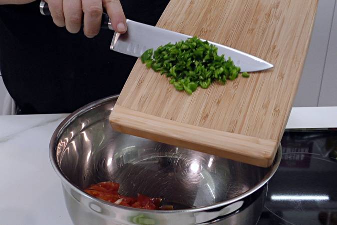 Picar el tomate, la cebolla y el pimiento verde