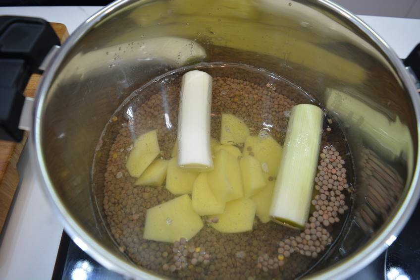 Poner a cocer las lentejas con los pimientos y la carne
