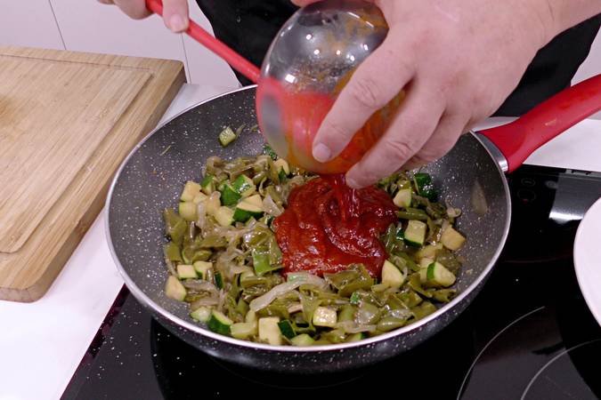 Agregar el tomate frito y terminar de cocinar el pisto